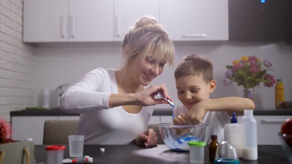 Happy Mom with Son Making Slime in Home Kitchen