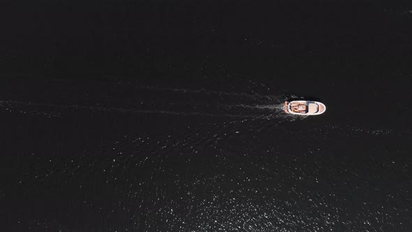 Aerial: top down view of motorboat on water, summertime leisure activity