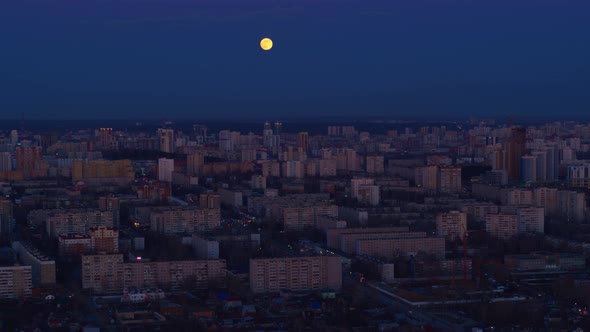 Aerial View of The Huge Moon Above the Night City