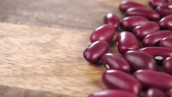 Red kidney beans on a rustic wooden textured surface. Macro. Unprocessed raw legumes