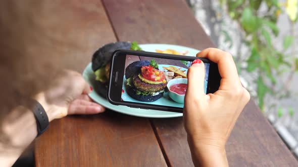 Woman Hand Taking Picture Of Burger With Smartphone