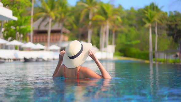 Young asian woman enjoy around outdoor swimming pool for leisure