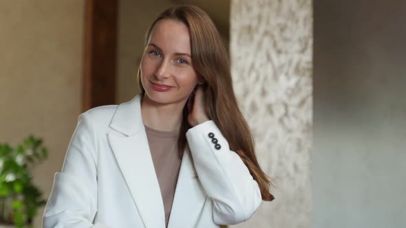 A Brunette in a White Jacket with Healthy Hair and Natural Makeup