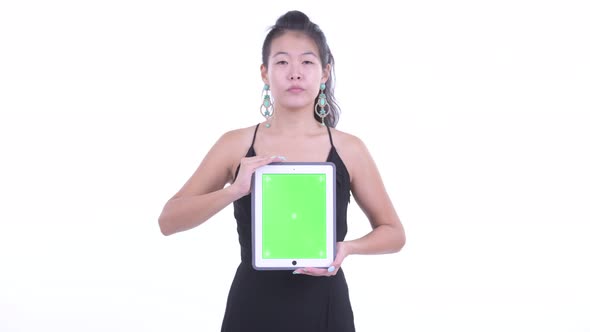 Stressed Asian Woman Showing Digital Tablet and Getting Bad News