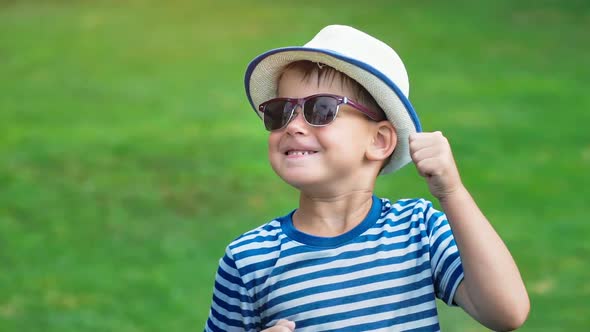 Portrait Happy Smiling Little Boy in Sunglasses and Hat Having Fun Dancing in Summer Park