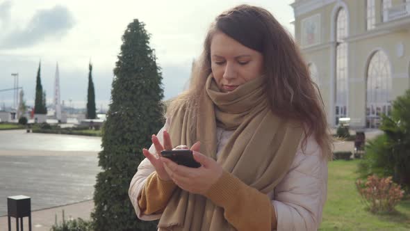 Stylish Woman with a Smartphone Outdoor.