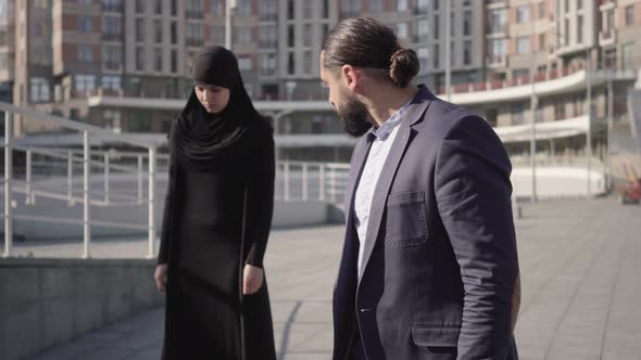 Middle Shot of Furious Middle Eastern Man Looking at Stressed Muslim Woman in Hijab