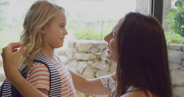 Daughter embracing her mother before leaving school at door in home 4k