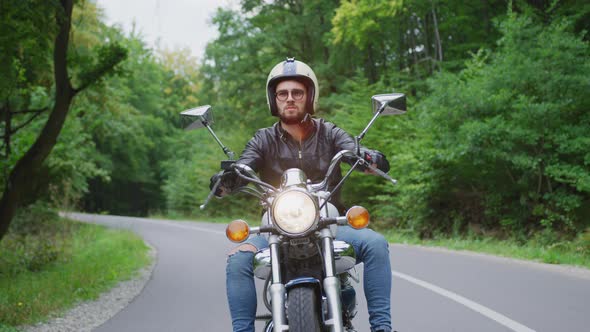 Riding a motorcycle on the empty road through the forest