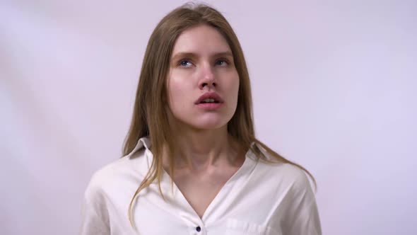 Portrait of Pretty Confident Thoughtful Girl Looking Seriously Up, Standing on White Background