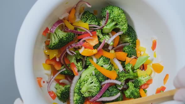 Professional Cook in Gloves Mixes Fresh Salad Ingredients