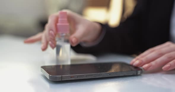 Woman Cleans the Modern Smartphone It with Antiseptic and Wipes the Process of Disinfection of the
