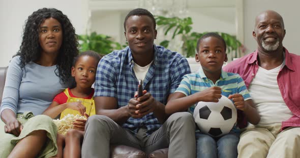 Happy african american family cheering while watching match in tv