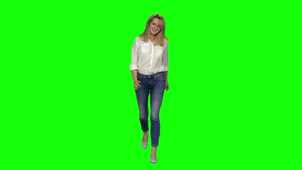 Blonde Woman Is Running with Smile on Green Screen. Chroma Key. Front View. Slow Motion