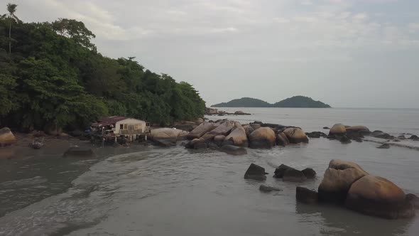 Aerial view fishing hut near the rock and coastal beside green forest