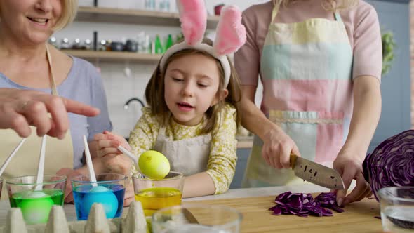 Tracking video of girl with grandmother taking out dyed eggs. Shot with RED helium camera in 8K.