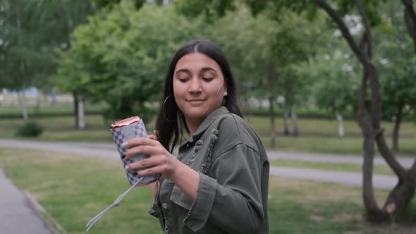 Young Stylish Brunette Girl in Good Mood in White Sneakers Dancing in the Park To the Music While