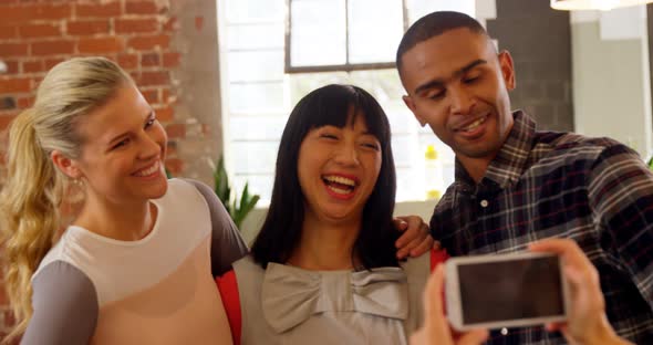 Group of executives reviewing picture on mobile phone 4k