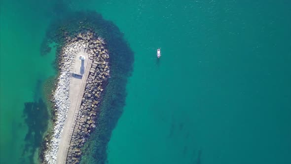 Aerial View Of Breakwater Stone Pier And Lighthouse