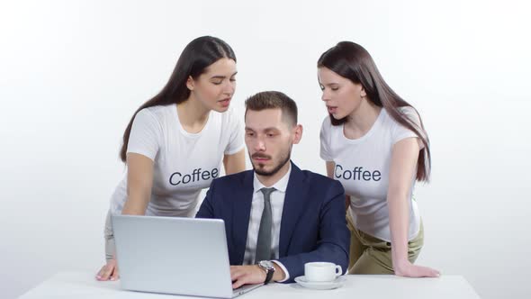 Women Tempting Businessman to Drink Coffee