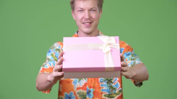 Young Handsome Tourist Man Giving Gift Box