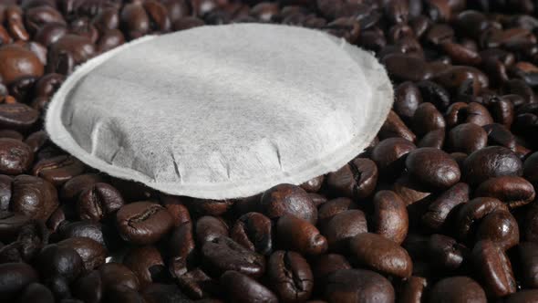 Tilting on single filter coffee pod on roasted  beans 4K footage