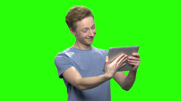 Positive Teenager Boy Holds Tablet PC