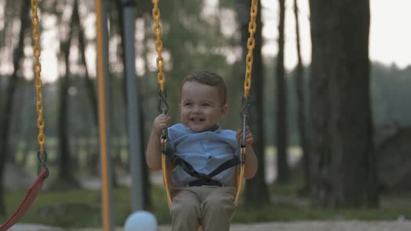 Happy Baby Rides on a Swing in Slow Motion