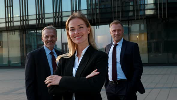 Business Team. Leader Woman in Front and the Team in Background. Business Building Exterior