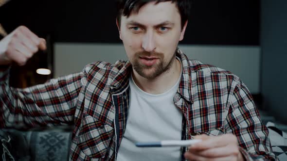 One Happy and Joyful Caucasian Man Holding Pregnancy Test at Home