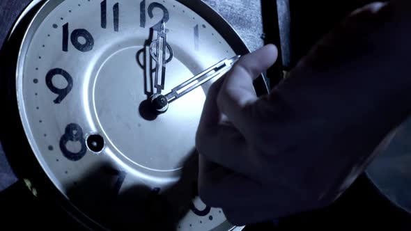 Close up of a  male hand is using the key to the ancient pendulum clock