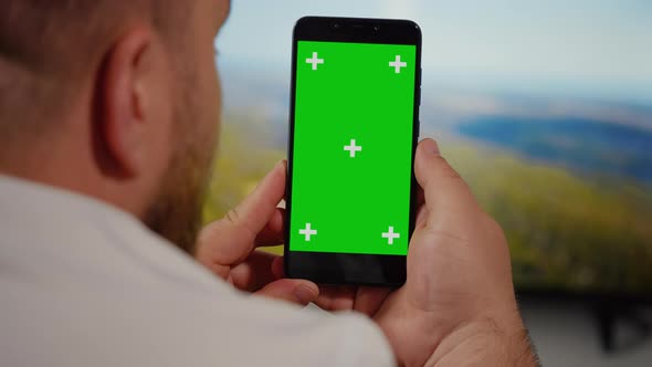 Man Watching on Smartphone Green Screen for Copy Space Chroma Key