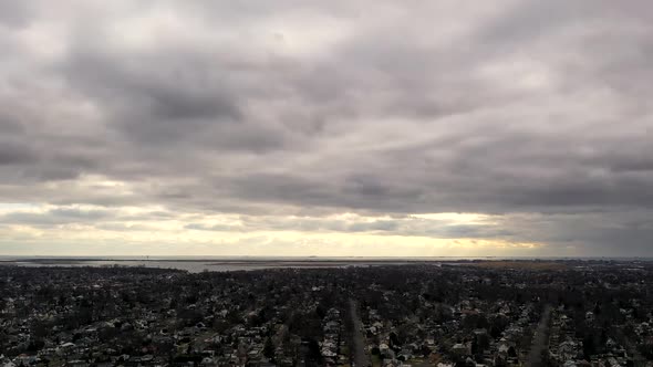 An aerial time lapse over a suburban neighborhood in the evening, just before sunset. The camera tru