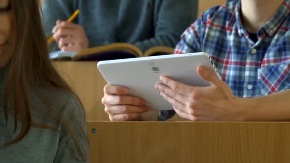 Male Student Shows His Classmate Something on Tablet