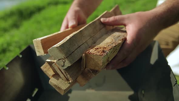 Man Puts Firewood in the Grill