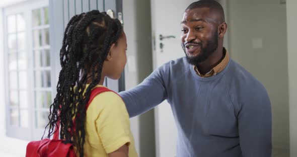 Happy african american father talking with daughter before leaving to school