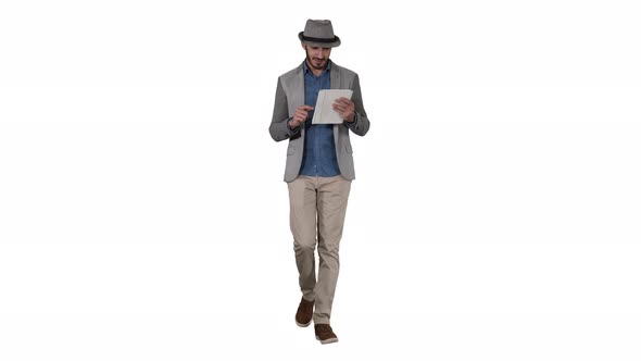 Handsome Smiling Arab Man in a Hat Walking and Using Tablet on White Background