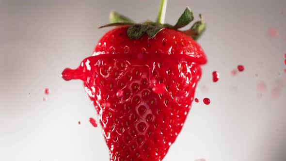 Strawberry Slice Falling and Splashing on White Background