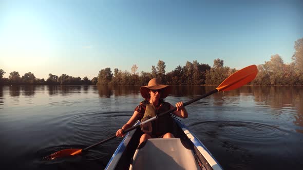 Woman Exploring Calm River By Canoe. Travel Girl In Kayak. Girl Traveler In Life Vest Swims In Kayak
