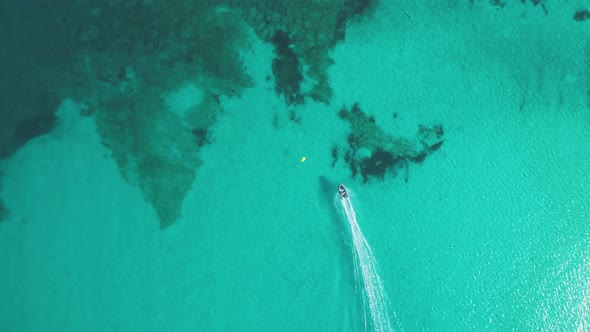 Boat sailing at high speed breaking through transparent waters