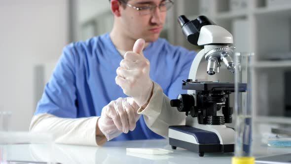 Male Scientist Using Microscope in Lab alt