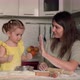Mom and Child Clap Each Other's Hands While Baking Dough and Laugh - VideoHive Item for Sale