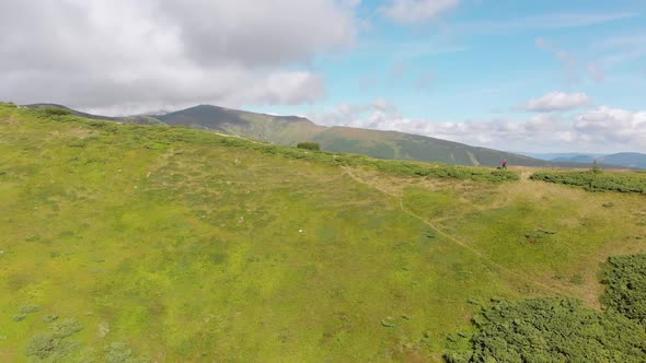 Aerial View of a Traveler with Backpack Climbing Along Mountain Slope. Epic Shot