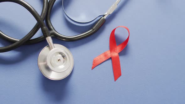 Video of stethoscope and red blood cancer ribbon on blue background
