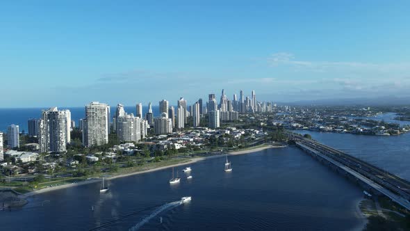 Unique high drone view of a metropolitan skyline surrounded by water with a tram and motor vehicle b