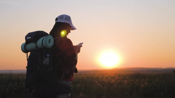 Silhouette of Young Tourist Woman Use Phone with Dramatic Sunset Sky Background. Always Connected