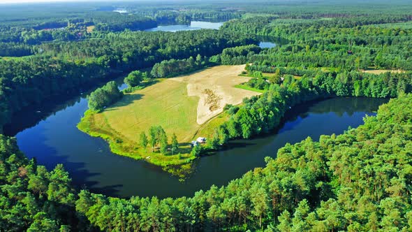 Curvy river and green forests at sunrise, aerial view