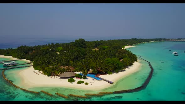 Aerial flying over seascape of tropical seashore beach lifestyle by blue green ocean with white sand