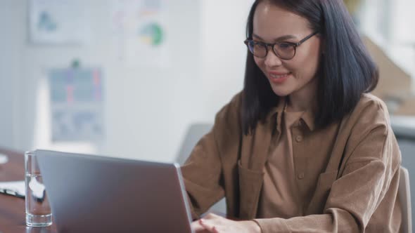 Asian Woman Enjoying Her Work In Office