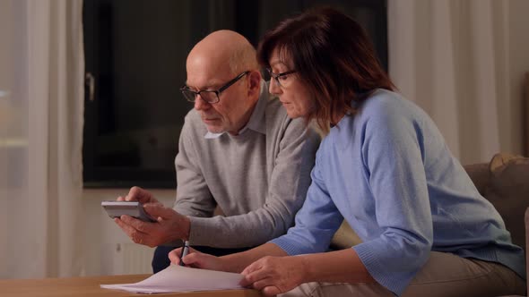 Senior Couple with Papers and Calculator at Home